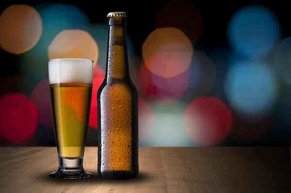Bier op houten tafel met nacht scène achtergrond — Stockfoto