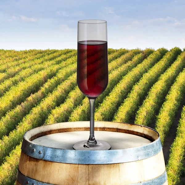 Glas Rotwein auf Holzfass mit Weinberg-Szene im Hintergrund — Stockfoto
