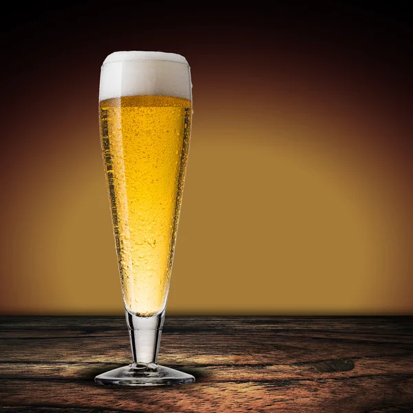 Szklanka zimnego piwa na stół z drewna — Zdjęcie stockowe