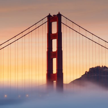 Golden Gate Bridge at sunset with fog