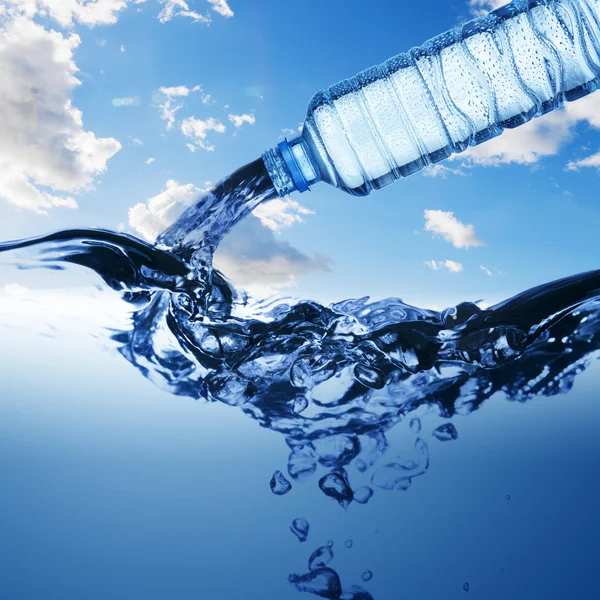 Water from water bottle with bubble forming on blue background — Stock Photo, Image