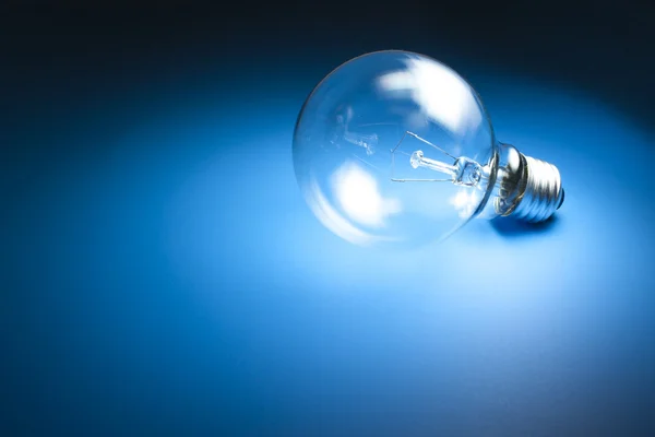 Light bulb on blue background — Stock Photo, Image