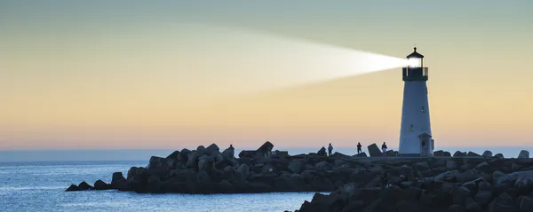 Faro con haz de luz al atardecer Imagen de archivo