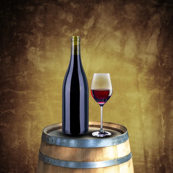 Red wine bottle and glass on wood barrel — Stock Photo, Image