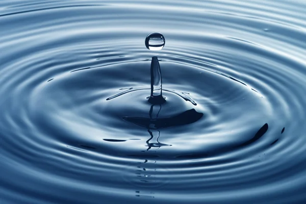 Water drop on blue water — Stock Photo, Image