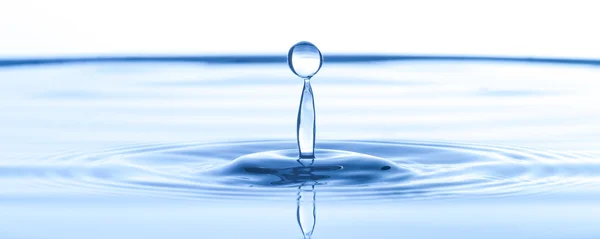 Vattendroppe på blått vatten — Stockfoto
