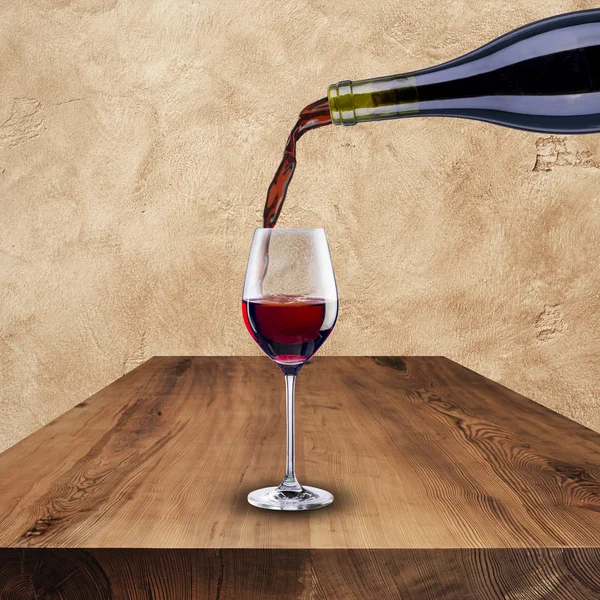 Vino tinto se vierte de botella a copa — Foto de Stock