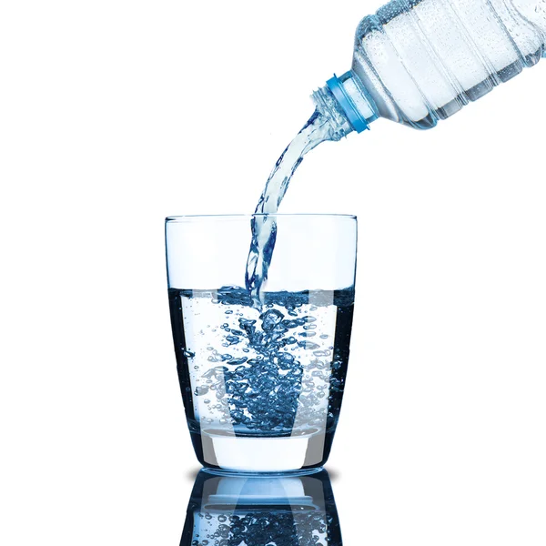 Koud water fles giet water aan de glazen — Stockfoto
