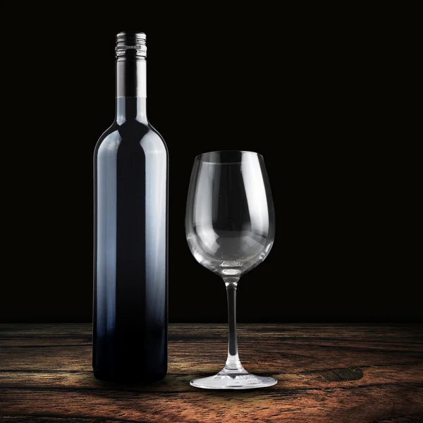 Bottle of red wine with empty glass — Stock Photo, Image