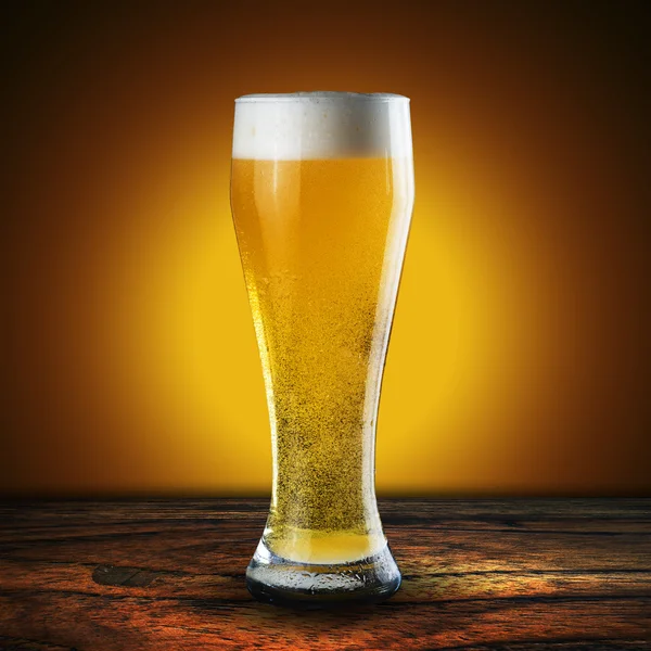 Szklanka piwa na stół z drewna — Zdjęcie stockowe