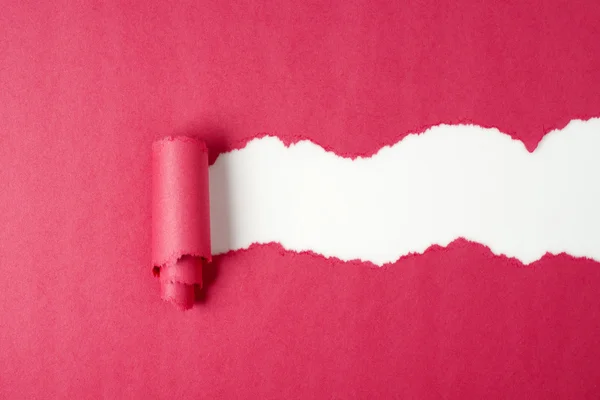 Loch in rotem Papier auf weißem Papier gerissen — Stockfoto