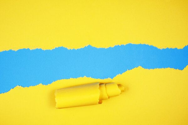 Torn yellow color paper on light blue color background