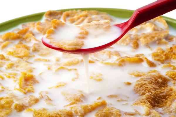 Cucchiaio rosso tuffo in Cereale con latte — Foto Stock