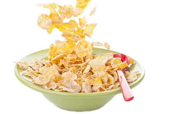Cereal cayendo en el tazón con cuchara roja — Foto de Stock