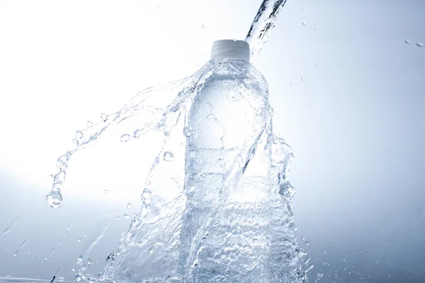 Fles water en water splash — Stockfoto