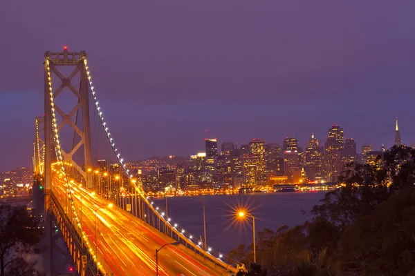 Bay bridge za soumraku s oceánem v popředí. — Stock fotografie