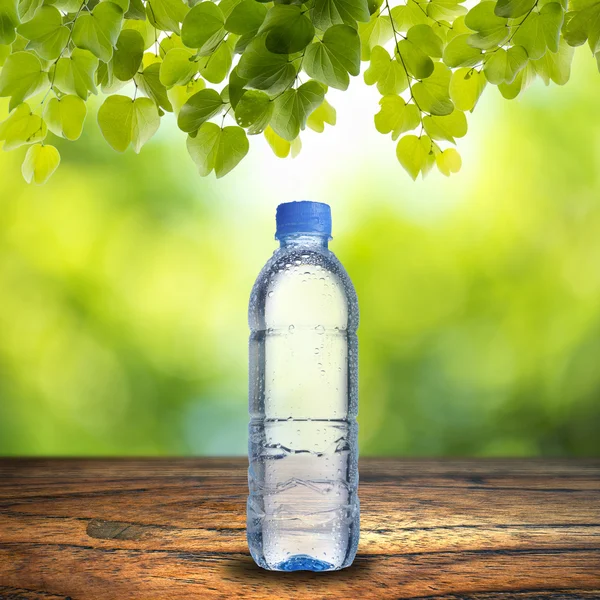 Láhev vody na dřevo stůl — Stock fotografie