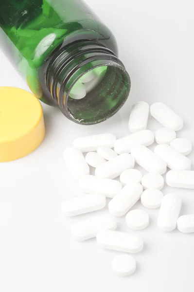 Medicine spilling out from small bottle — Stock Photo, Image