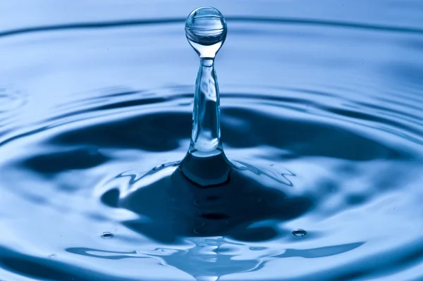 Wassertropfen auf blauem Wasser — Stockfoto