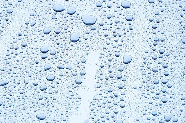 Gota de água no fundo de cor azul — Fotografia de Stock