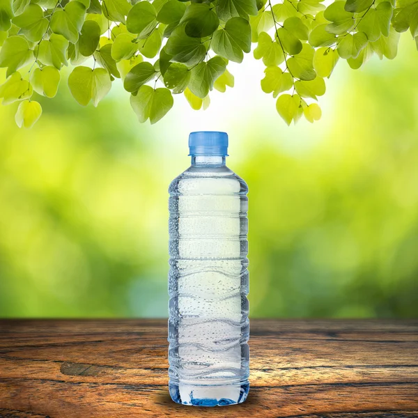 Flaska vatten på bord av trä — Stockfoto