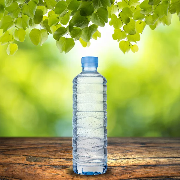 Bouteille d'eau sur table en bois — Photo