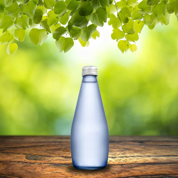 Fles water op houten tafel — Stockfoto