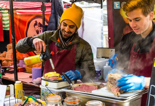 Melting cheese using a blow torch at Camden Market — Stock Photo, Image