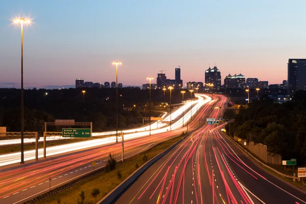 Trilhas de luz em uma rodovia ao entardecer — Fotografia de Stock