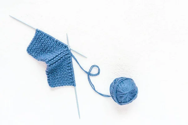 白色混凝土背景上的蓝色针织 毛球和针织针织 业余爱好和针织 复制空间 — 图库照片