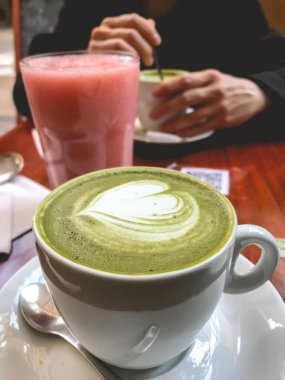 Lezzetli büyük bir bardak kibritli latte (Japon yeşil kibrit çayı ve sütü) ve doğal meyve suyu bardağıyla öğleden sonra çay randevusu.