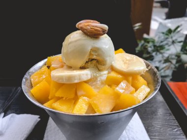 Güzel ve lezzetli 'Patbingsu' (tatlı kırmızı fasulye ve meyveli buzlu Kore tatlısı) muz, mango ve badem.