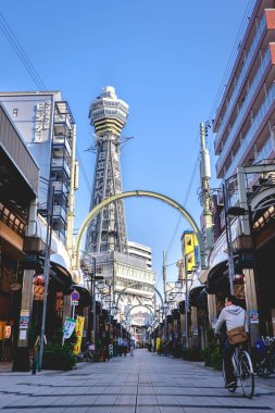 Osaka, Japonya: Tsutenkaku kulesi, restoranlar, tabelalar, renkler ve bisikletli insanlar ve Shinsekai ilçesi sokaklarında yürüyorlar