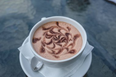 Köpüklü güzel bir mochaccino kahvesi (çikolata ve kahve), cam bir masanın üzerinde, Valdivia, Şili