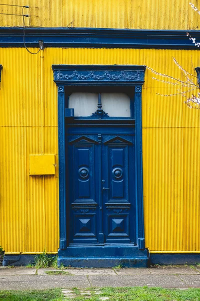 智利巴尔迪维亚 蓝色的旧木门 墙上挂着黄色金属片 — 图库照片