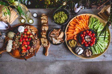 Lezzetli ve renkli vejetaryen-vejetaryen servis masası kereviz, kiraz domatesleri, havuç, humus, avokado, tost ve zeytin, vegan peyniri, çilek, fındık ve kraker