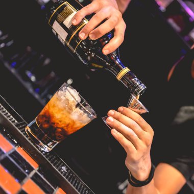 Genç Latin barmenin, gece bardan nefis bir kokteyl hazırladığı yakın plan.