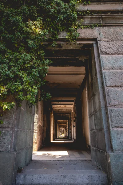 Abandoned ruins of old centuries stone mausoleum with neoclassical architecture between trees and plants with sunlight