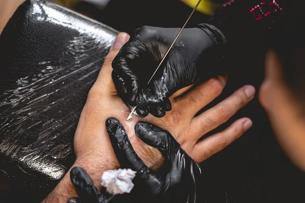 黒手袋のタトゥーアーティストの手の詳細伝統的な日本の 手ポーク 技術を持つ男の手の中に陰陽の白い色合いと新しい入れ墨を作る — ストック写真
