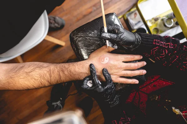 Detal Rąk Tatuażysty Czarnych Rękawiczkach Robiącego Nowy Tatuaż Białym Odcieniem — Zdjęcie stockowe