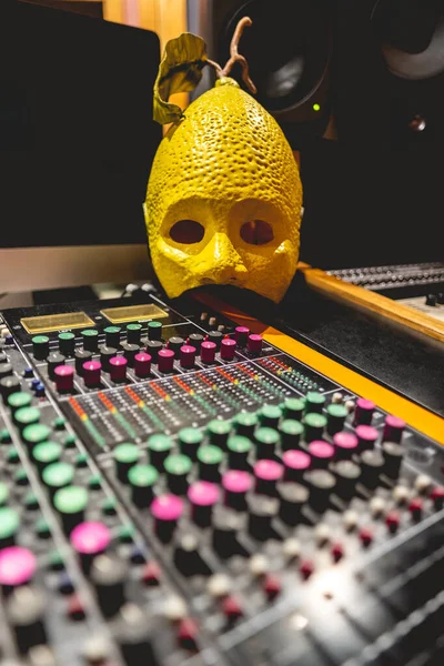 レモン男マスク上のサウンドミキサーボードでいくつかのノブでスタジオ — ストック写真