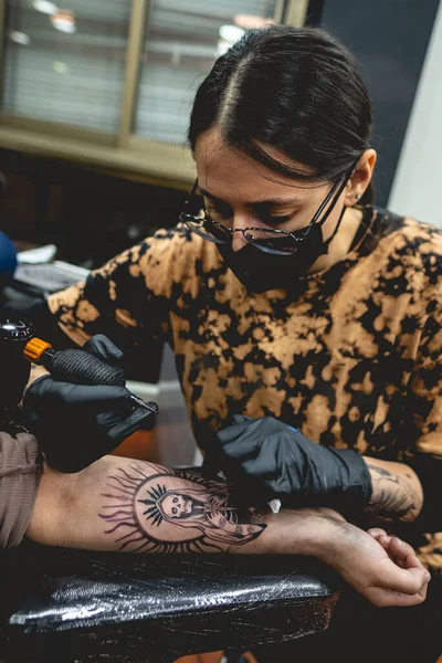 Joven Artista Del Tatuaje Con Gafas Máscara Haciendo Tatuaje Santa —  Fotos de Stock