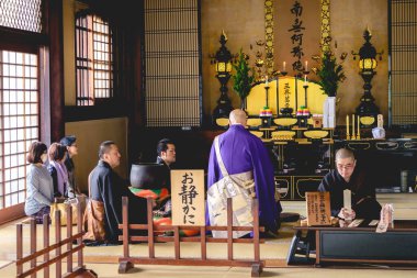 Japonya 'nın Osaka kentindeki Isshin-ji Budist Tapınağı' nda insanlar dua ediyor ve rahipler bir tören düzenliyor.
