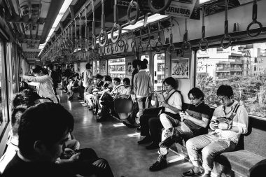 Osaka, Japonya: Farklı kişiler (öğrenciler, maaşlı erkekler, kadınlar, vs.) öğleden sonra güneş ışığıyla metro vagonunda (siyah ve beyaz))