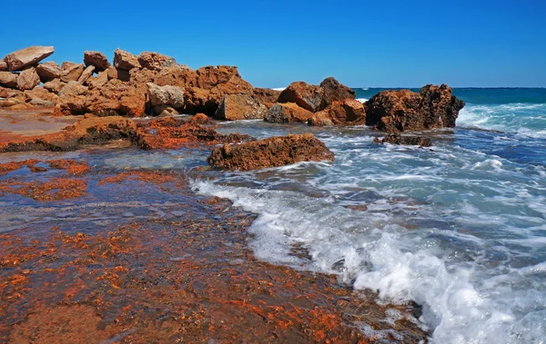 Reusachtige rotsen aan de kust van de storm-zee Stockfoto