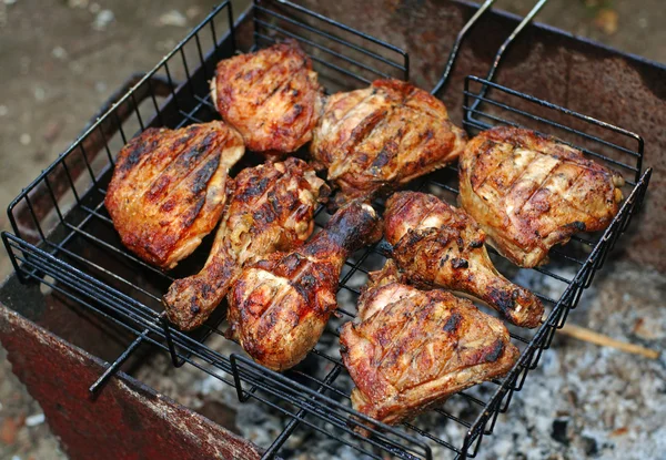 Kip benen op de grill voor barbecue Stockafbeelding