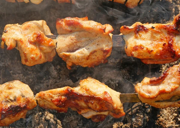 Chunks of turkey on a spit in the smoke — Stock Photo, Image