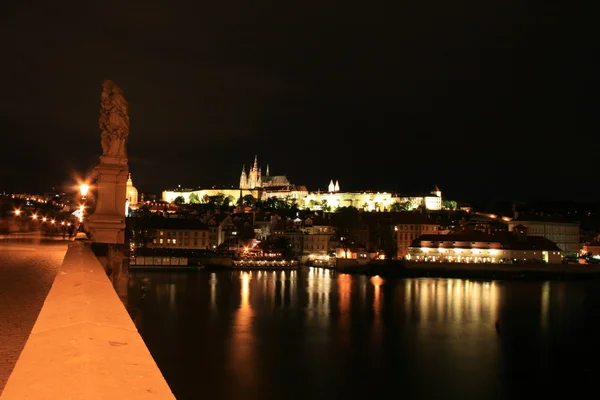 Den magnifika Pragborgen på natten längs floden vltava — Stockfoto