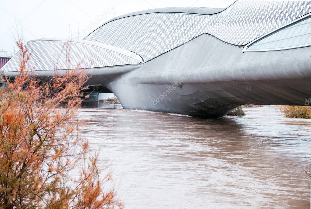 Ebro river increase its waterflow in the aftermath of Barra storm in Spain. Pabellon puente, one of the most emblematic bridges of Zaragoza is in the background