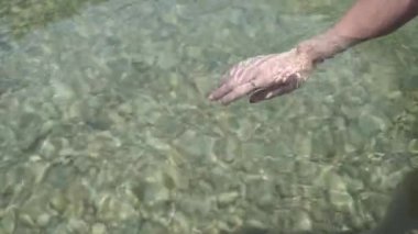 İspanya 'da turistik bir köprünün önünde güneşlenen güzel bir kadının 4K yatay videosu. Turkuaz bir nehirde bronzlaşmaya çalışıyor. O yalnız. 